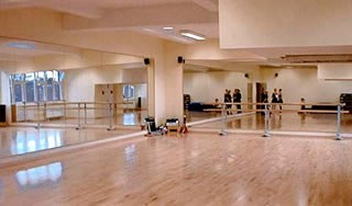 Ein heller Tanzsaal mit Spiegelwand im Tanzhouse